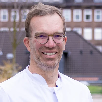 Prof. Dr. med. Thomas Bitter im weißen Arztkittel vor dem Städtischen Klinikum Braunschweig