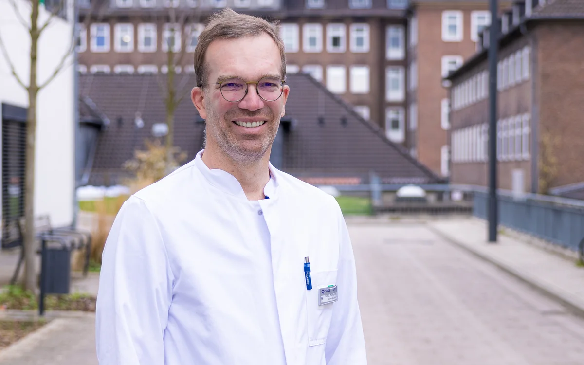 Prof. Dr. med. Thomas Bitter im weißen Arztkittel vor dem Städtischen Klinikum Braunschweig